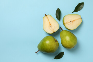 Fresh green pears on blue background, top view