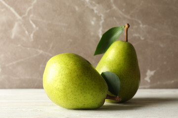 Fresh green pears on wooden table against gray background