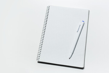 Top view of notepad and pen on white background.