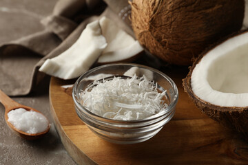 Board with coconut and coconut flakes on gray table