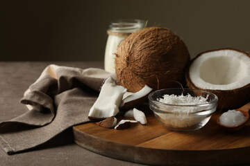 Board with coconut and coconut flakes on gray table