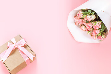 Pink roses bouquet and gift box on pink background, Valentine's day background