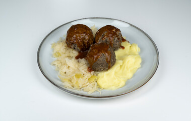 Eine Portion gekochter, pfälzer Leberknödel mit Sauerkraut, Kartoffelpüree und brauner Sauce,