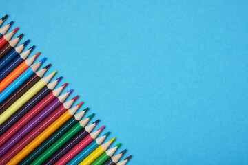 color pencils on blue background copy space