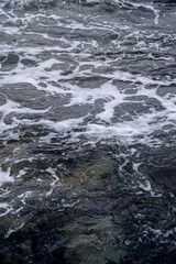 Waves at the seashore or pier. Selective focus with shallow depth of field.