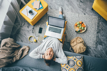 Young woman working with laptop and having a break at home.