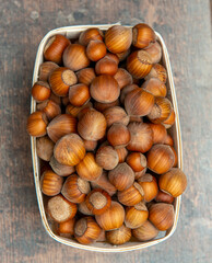 Hazelnuts in  small crate on rustic background