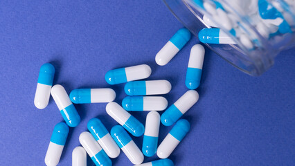 White and blue pills on a blue background. medical background