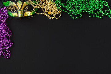 Mardi gras background on black with mask, beads and copy space
