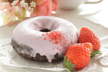 Pink strawberry chocolate coating donut served with strawberry