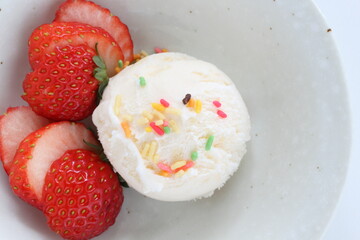 Vanilla ice-cream served with sliced strawberry