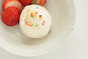 Vanilla ice-cream served with sliced strawberry