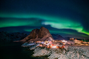 Obraz na płótnie Canvas Aurora borealis on the Hamnoy village in Lofoten islands, Norway. Green northern lights above mountains. Night sky with polar lights. Night winter landscape.