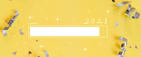 close up on loading bar to year of 2021 handwritten with group of silver color of rolling ribbon and confetti on yellow background for festival ,carnival and anniversary, concept design