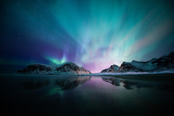 Aurora Borealis am Strand auf den Lofoten, Norwegen. Grüne Nordlichter über Bergen. Nachthimmel mit Polarlichtern. Nächtliche Winterlandschaft.