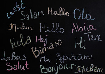 The word "Hello" is written in different languages ​​and colors on the board. The concept of learning different languages. International relations. Greetings in different languages.