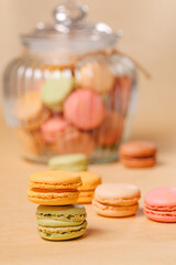 Macaroons of different colors in a glass container. Macarons of different colors