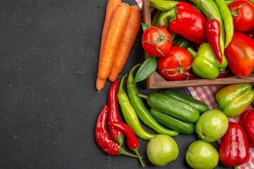 Collection of fresh various organic vegetables on orange stripped towel on dark background