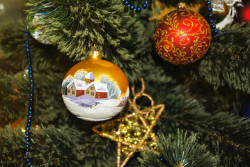 Christmas toys hanging on artificial spruce tree in house closeup