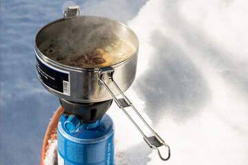 Suppe kochen auf Gaskocher, im Schnee, Schweiz
