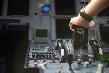 Cropped hands of pilot flying a commercial airplane, cockpit view close up of hands. Captain hand accelerating on the throttle in commercial airplane