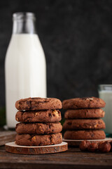 Chocolate cookies with glass of milk on wooden table.