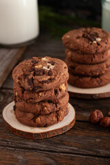 Chocolate cookies with glass of milk on wooden table.