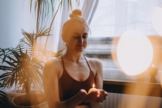 Self-care, self-compassion, mental wellbeing in post-pandemic world. Mental health, wellbeing, meditation to eliminate anxiety. Young woman sitting on floor do yoga exercise and meditation at home