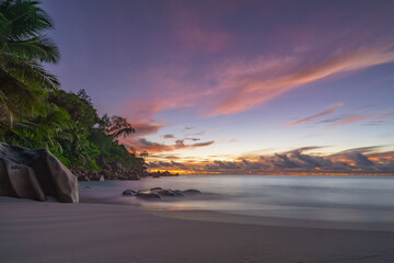 sunset at tropical beach anse georgette on praslin, seychelles