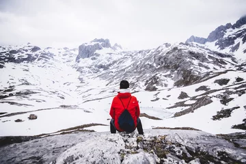 Fotobehang   Man alone siting looking to the mountains © Aritz Tabuyo