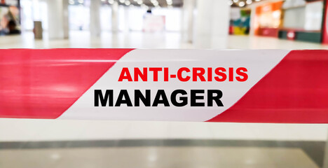 Anti crisis manager expression on a forbidden tape against a closed business background.
