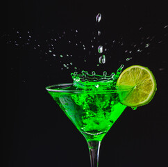 Green drink in a glass. Green water or limnad. A splash of green liquid similar to absinthe. Alcohol and alcoholism.
