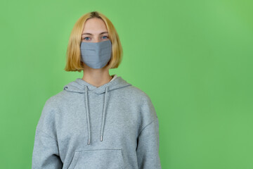 Frau mit Kapuzenpulli un Maske