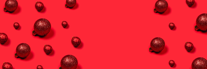 Minimalistic bright composition. Christmas festive banner with red toys and place for text in center.