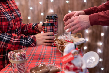 Man  customer buying hot chocolate, coffee in a paper cup, sweets at the christmas bakery. Take away.