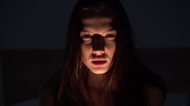 The illuminated face of a young woman