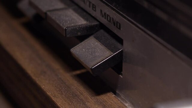 Closeup, Finger pushes down button on dusty old radio