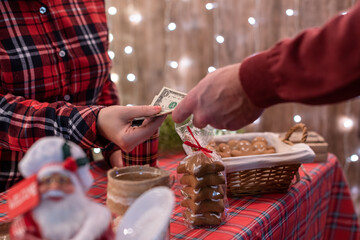 Man  customer buying coffee latte in a paper cup, sweets at the christmas bakery giving dollars to the woman selle