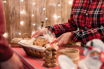 Woman seller showing a basket of gingerbread, sweets at the bakery lying in a straw basket on the counter.