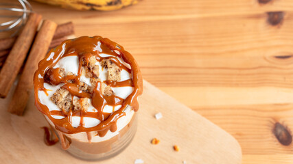 Fresh organic homemade baked bakery banana trifle layer parfait with brown sugar caramel white milk butter cream crust crumble topping and very ripe bananas bread loaf slice for cafe sweet desserts