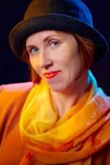 Portrait of middle-aged woman with hat. Ugly model in yellow autumn stile posing in studio.