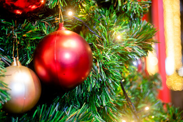 Balls on christmas tree, bokeh lights and holly wreath.