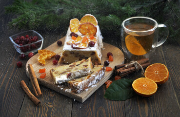 Homemade tangerine cupcake. Fir branches, spices and a cup of tea on a dark wooden table.