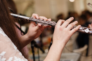Flutist, young girl playing the flute, hands, fingers on keys closeup, children playing transverse side blow flute, detail shot, classical music, wind instrument performance player up close abstract - obrazy, fototapety, plakaty