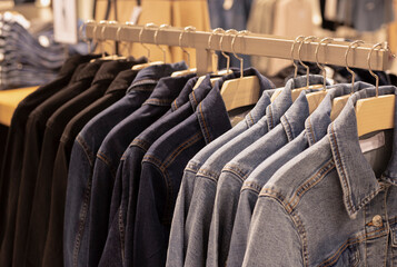 Women clothing - fall winter collection. denim jackets on hangers in the store. the concept of conscious consumption and recycling of things