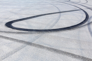 Black burnt rubber drift traces made by cars on asphalt