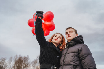 Love couple with red balloons outdoor