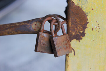 close up  rusty locks between a steel pole. Security concept. Vintage padlock.