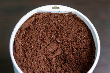 Roasted ground arabica beans in an electric coffee grinder.