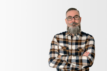 man with wide beard, glasses and plaid shirt, standing with crossed arms staring with serious face....